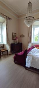 a bedroom with a bed and a chandelier at St Mary House in Tomar