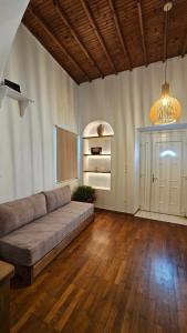 Eleanna's Mykonos في مدينة ميكونوس: غرفة معيشة كبيرة مع أريكة وأرضية خشبية