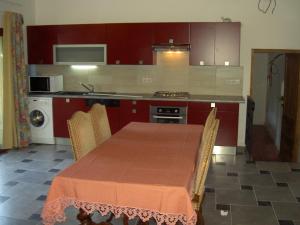 a kitchen with a table with chairs and a kitchen with a stove at Gîtes de La Palombière in Les Eyzies-de-Tayac