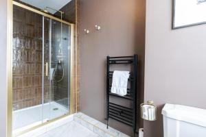 een badkamer met een douche en een glazen douchecabine bij The King in Fowey