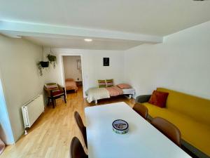 uma sala de estar com uma mesa e uma cama em 5 minute walk to LEGO house-70m2 apartment with garden-unit C em Billund