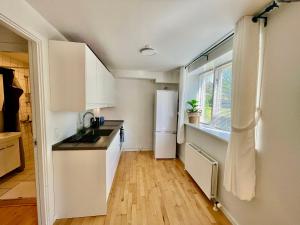 uma cozinha com um frigorífico branco e uma janela em 5 minute walk to LEGO house-70m2 apartment with garden-unit C em Billund