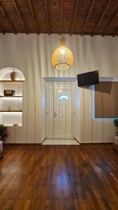 Zimmer mit einer Tür, einem TV und einer Lampe in der Unterkunft Eleanna's Mykonos in Mykonos Stadt