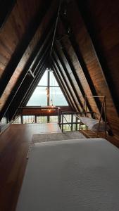 Zimmer im Dachgeschoss mit einem Bett und einem großen Fenster in der Unterkunft Trabzon Silent Hill Bungalow in Trabzon