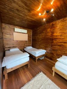 a room with three beds and a wooden wall at Trabzon Silent Hill Bungalow in Trabzon