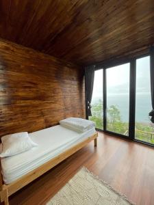 Bett in einem Zimmer mit einer Holzwand in der Unterkunft Trabzon Silent Hill Bungalow in Trabzon