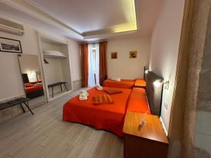 1 dormitorio con 2 camas con sábanas de color naranja en Affittacamere Resalibera, en Siracusa