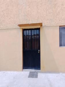 una porta nera sul lato di un edificio di Departamento Bernal a Bernal