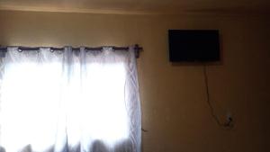 una camera con finestra con tende e televisore di Departamento Bernal a Bernal