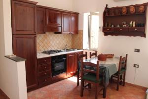 una cocina con armarios de madera y una mesa con sillas. en Smile At Vesuvio, en Nápoles