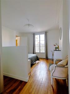 ein weißes Zimmer mit einem Bett und einem Sofa in der Unterkunft Cerise - L'escale Paris Orly Airport in Choisy-le-Roi