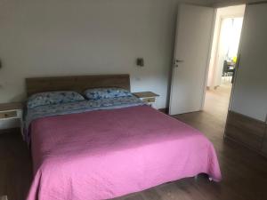 um quarto com uma cama grande e um cobertor rosa em Appartamento Villa lucia em SantʼEufemia Lamezia