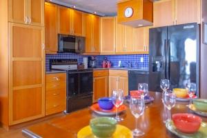 a kitchen with wooden cabinets and a table with wine glasses at Islander East Condominiums in Galveston