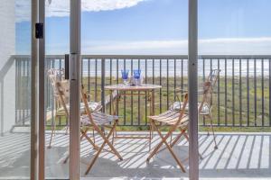 un tavolo e sedie su un balcone con vista sull'oceano di Islander East Condominiums a Galveston