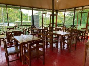 a row of tables and chairs in a room with windows at Amazon Açaí Lodge in Leticia