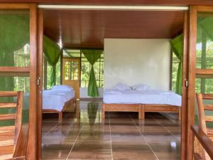 two beds in a room with glass doors at Amazon Açaí Lodge in Leticia