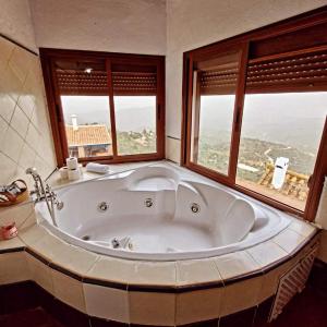 W łazience z 2 oknami znajduje się duża wanna. w obiekcie Hotel Rural Verde Oliva w mieście Comares