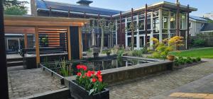 ein Haus mit einem Teich vor einem Gebäude in der Unterkunft Artz of Nature in Emmen