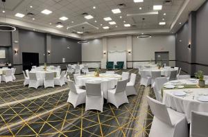 a conference room with white tables and white chairs at Holiday Inn & Suites Phoenix-Mesa-Chandler, an IHG Hotel in Mesa