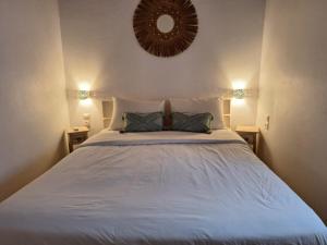 ミコノス・シティにあるEleanna's Mykonosのベッドルーム1室(壁に鏡が付いた白いベッド1台付)
