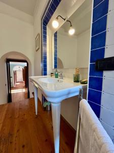 瓦雷澤的住宿－Kibilù - Via Virgilio，浴室设有白色水槽和蓝色瓷砖