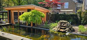 ein Haus mit einem Fischteich im Garten in der Unterkunft Artz of Nature in Emmen + 65 Fotos