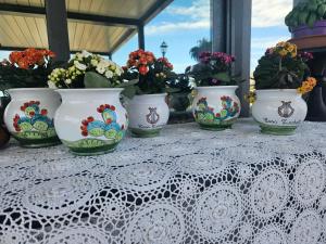 un groupe de vases assis sur une table avec des fleurs dans l'établissement Casa Turchetti, à Taormine