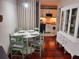 a dining room with a table and chairs and a kitchen at Apartamento En Camino - NEST Milladoiro in Milladoiro +15 photos