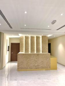 una hall con un muro in pietra al centro di Iveria Hotel Apartments a Ḩayl Āl ‘Umayr