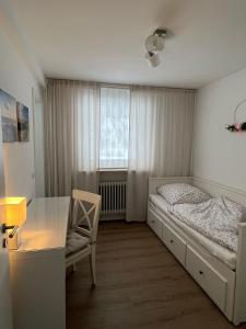 a bedroom with a bed and a desk and a window at Landhus-Sylt in Archsum