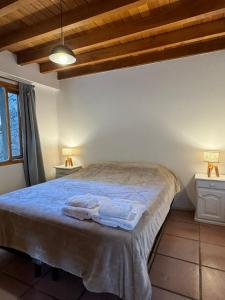 a bedroom with a bed with towels on it at Huilen de Bandurrias in San Martín de los Andes