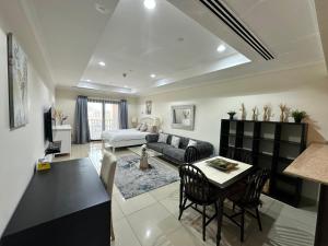 a living room with a couch and a table at Alken Studio - Amazing Superior Studio with Marvellous Marina View in the Pearl, Doha in Doha