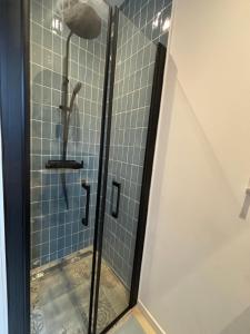 a shower with a glass door in a bathroom at La petite maison de Celestine in Plonéour-Lanvern