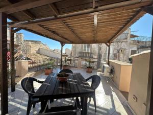 a wooden table and chairs on a patio at Affittacamere Resalibera in Siracusa