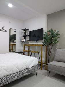 a bedroom with a bed and a tv and a chair at WUER Expiatorio in León