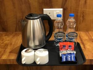 a tray with a coffee pot and water bottles at Hampton Hotel - 100 mt from Golden Temple in Amritsar