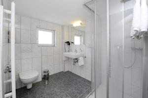 a white bathroom with a toilet and a sink at Aktiv-Ferienwohnungen Montafon in Sankt Gallenkirch +30 photos