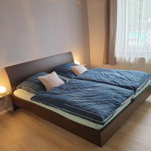 ein Bett mit blauer Bettwäsche und Kissen in einem Schlafzimmer in der Unterkunft Das Düsselapartment in Haan