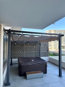 una cama bajo un dosel en un balcón en Dpto nuevo Reñaca gran terraza, en Viña del Mar