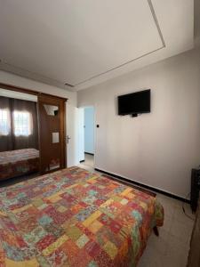 a bedroom with a bed and a flat screen tv on the wall at Bab Ezzouar in Bab Ezzouar