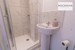 uma casa de banho com um chuveiro e um lavatório. em 10A Cromwell Road - Elegant & Modern 3 Bedroom Apartment in Central Grays with 5 beds em Grays Thurrock