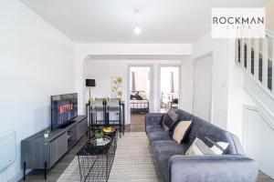 uma sala de estar com um sofá e uma televisão em 10A Cromwell Road - Elegant & Modern 3 Bedroom Apartment in Central Grays with 5 beds em Grays Thurrock
