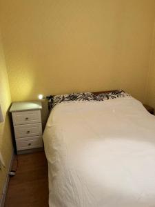 a small bedroom with a bed and a night stand at Kilmactrasna Cottage in Carrickmacross