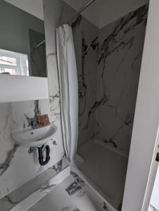 biała łazienka z umywalką i prysznicem w obiekcie Studio 1 w Bremie