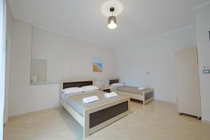 um quarto branco com duas camas e uma mesa em Hotel Deja Vu em Ksamil