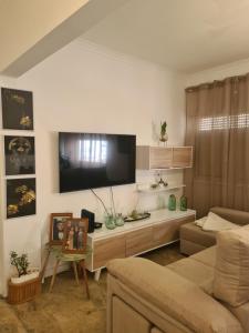 a living room with a couch and a flat screen tv at Quarto Santiago in Corroios