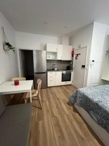 Cet appartement comprend une chambre avec un lit et une table ainsi qu'une cuisine. dans l'établissement Estrela da Almada Mascarenhas, à Almada