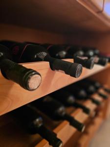 una fila de botellas de vino en una estantería de madera en Casa Grad, en Vişeu de Sus