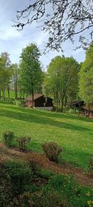 un campo de césped verde con una casa en el fondo en Chalet 9 La Boverie, en Rendeux