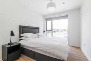 a white bedroom with a large bed and a window at The Cornerstone Two by Dublin At Home in Dublin